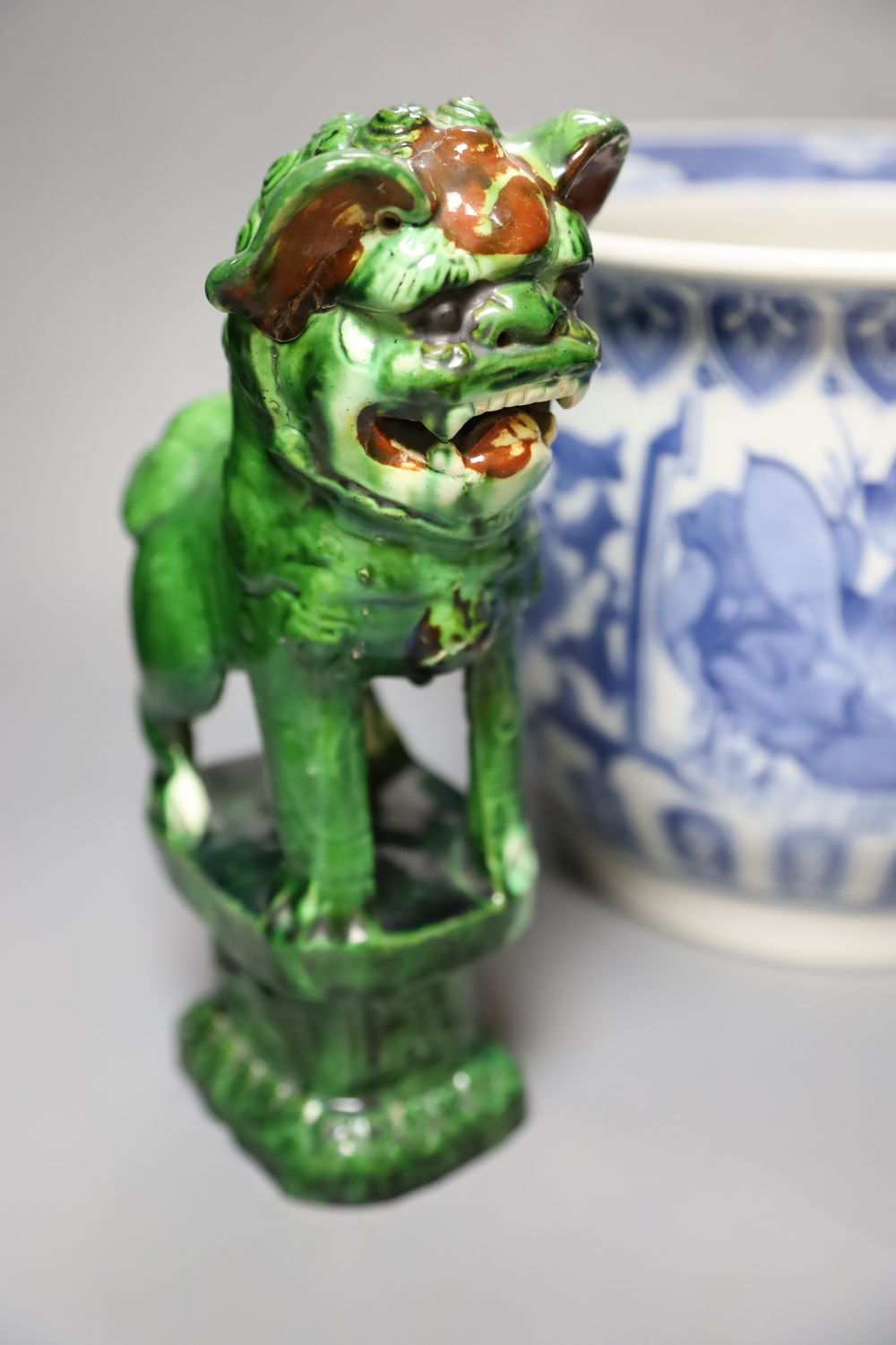 A Chinese blue and white jardiniere, a green glazed lion dog and a famille rose dish